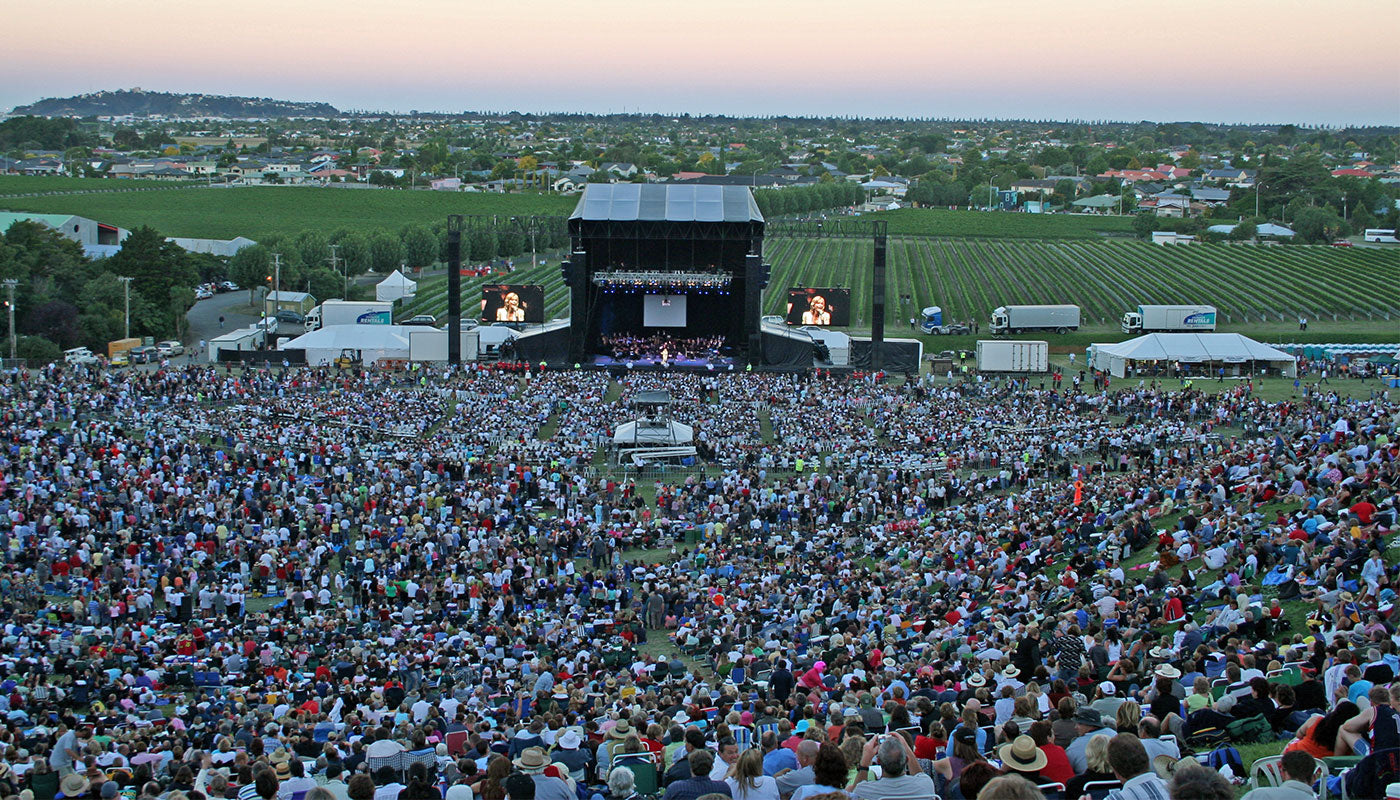 Large outdoor concert at Mission Estate with a stage and audience in a vineyard